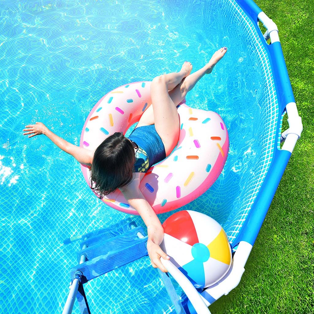 Young child playing in above ground swimming pool